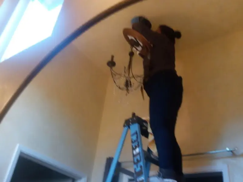 Electrician installing a chandelier in a Fairfield residence